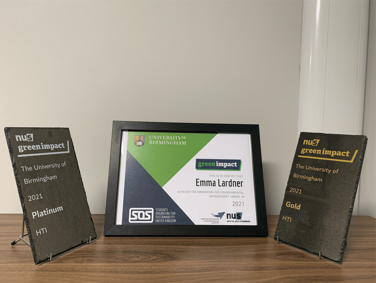 Photograph of the NUS green impact awards. Gold and platinum slate plaque and a framed innovation for environmental improvement award for Emma Lardner
