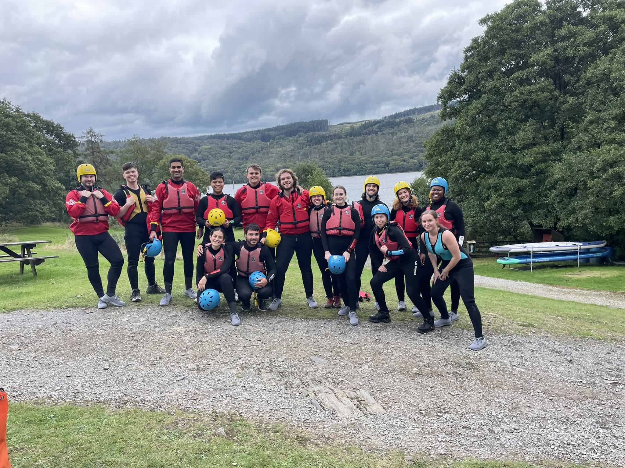 The 2021 cohort are in water sports kit standing in front of Lake Coniston